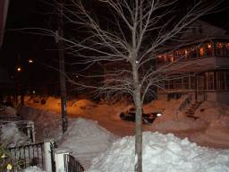Huge snow drifts line the not yet plowed street.